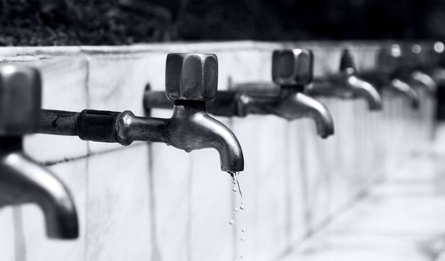 A long line of water faucets dripping water