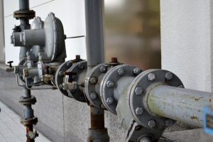 A gray water pipe running outside a building