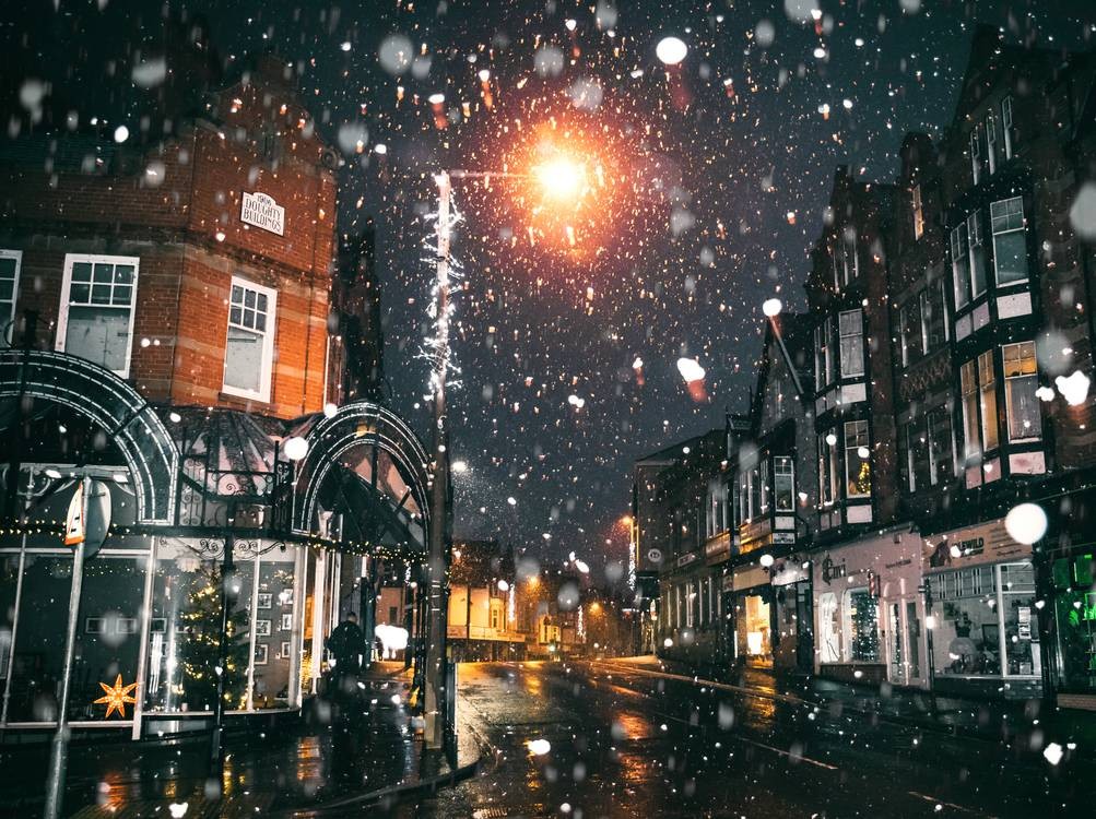snow falling in a town square