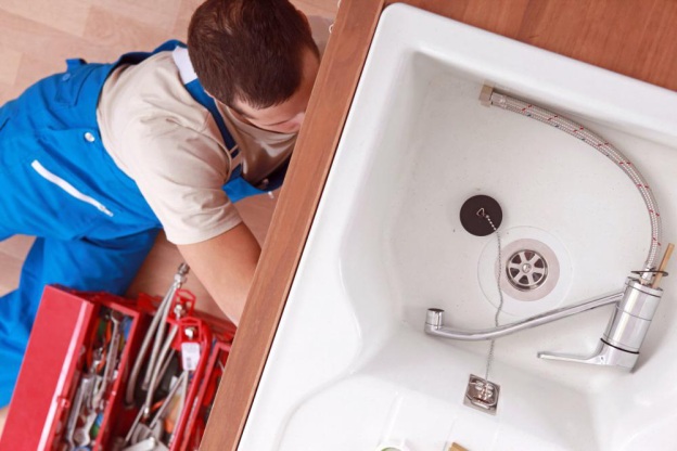 plumber repairing kitchen plumbing