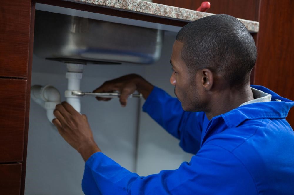 A plumber from Fort Worth repairing sink drains.