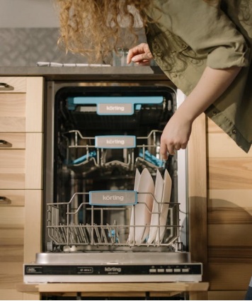 A person putting dishes inside a dishwasher