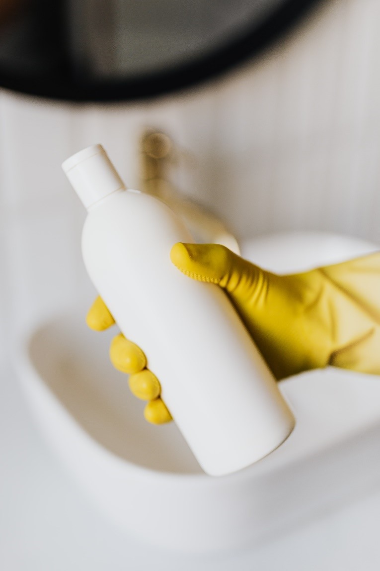 A professional drain cleaner wears gloves and uses specialized drain openers