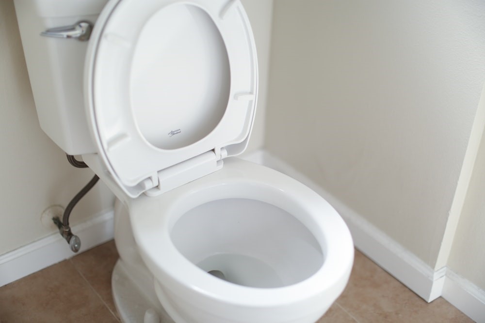 A white toilet with the seat up