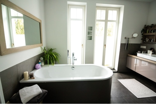 tiled-bathroom-white-bathtub-doors-plants-candles-sunlight