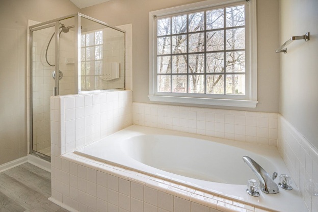 white-bathtub-tiled-bathroom-window-shower-area