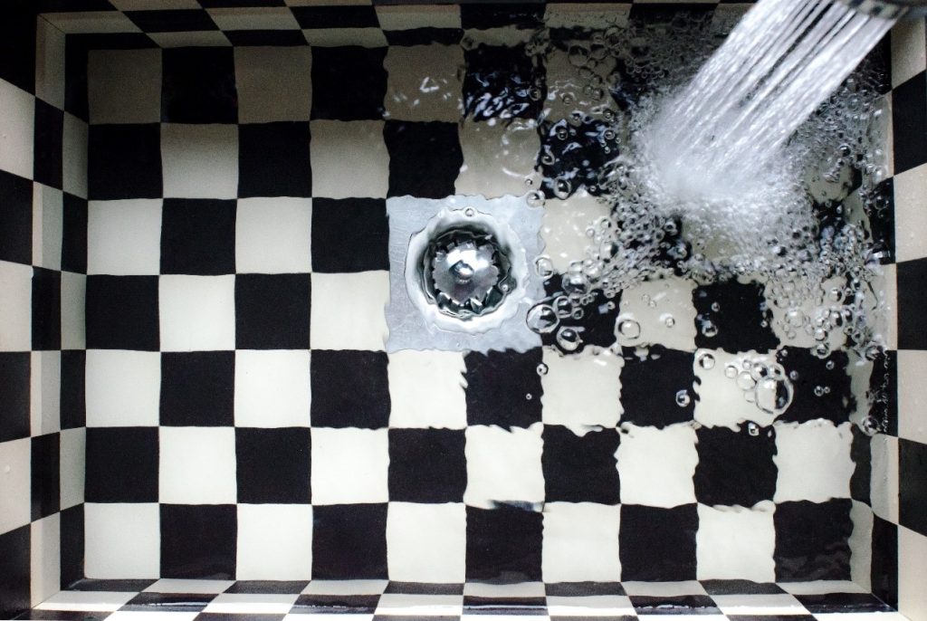 water collects as the bathroom is in urgent need of a drain cleaning service in Fort Worth