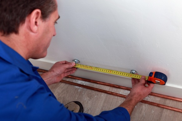 Plumber measuring pipes for repair